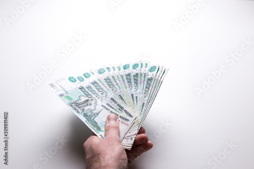 Male hand holds Russian rubles on a white isolated background.
