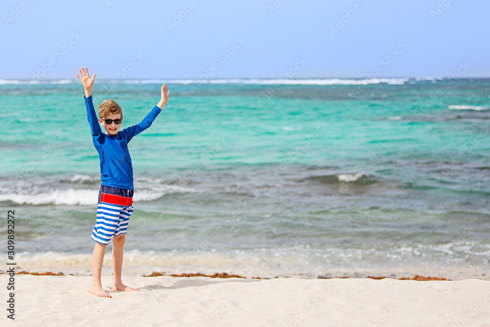 boy in rashguard and swimwear at the beach
