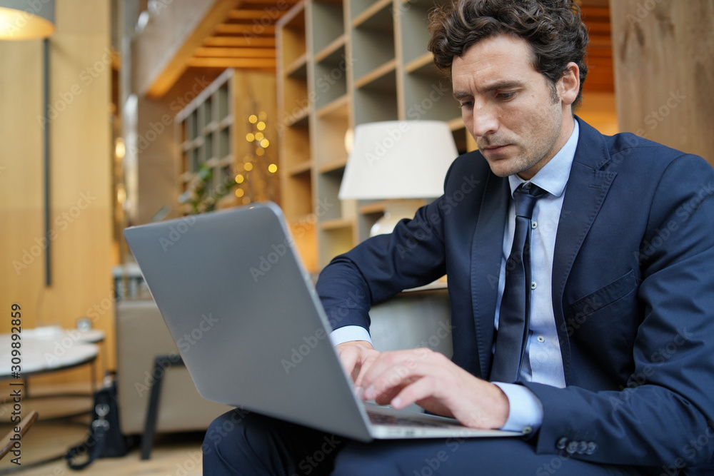 Businessman connected on laptop in hotel lounge Businessman connected on laptop in hotel lounge