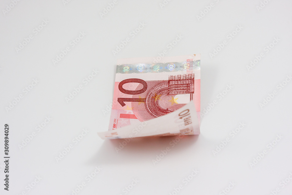 Slightly curled ten euro bill lies on white background Slightly curled ten euro bill lies on white background