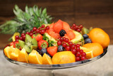 Plate with fruits and berries at the party. Fresh fruit on the metal plate. Healthy snack and treat. Food photography. Watermelon, pineapple, grapes, oranges, kiwi, strawberry, red currant