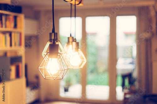 Lightning lamps at home, in restaurant or cafe: Close up of a hanging, orange lightbulbs