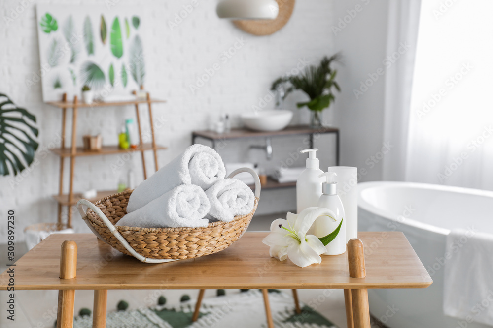 Clean towels with cosmetics on table in bathroom Clean towels with cosmetics on table in bathroom
