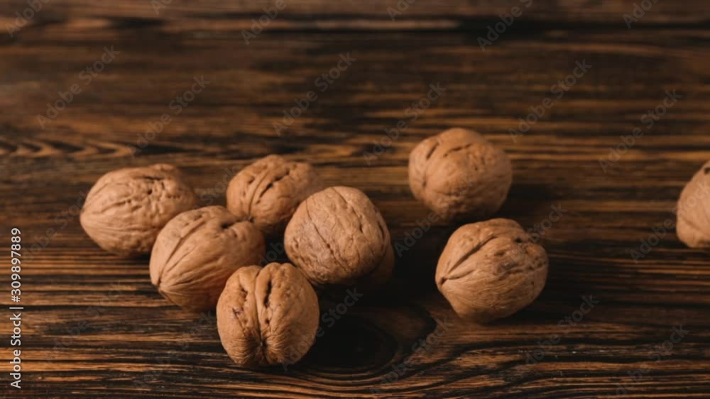 Female hands with tasty walnuts on wooden background Female hands with tasty walnuts on wooden background