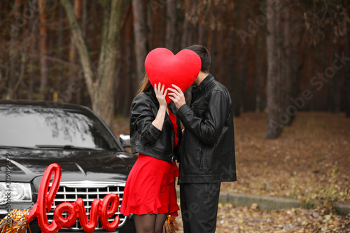 Happy young couple with red...