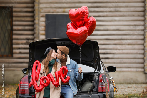 Happy young couple with car...