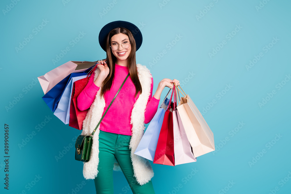 Portrait of her she nice-looking attractive cheerful cheery girl carrying new clothing things buyings spending weekend isolated on bright vivid shine vibrant green blue turquoise color background