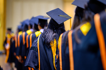 The back of the graduates are walking to attend the graduation ceremony at the university