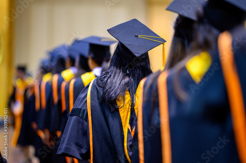 The back of the graduates are walking to attend the graduation ceremony at the university