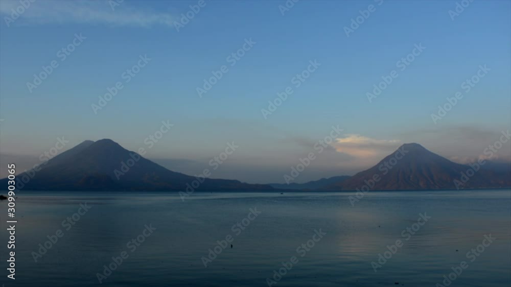 Cinematic aerial shot of Atitlan lake on a sunrise, with huge Volcanoes on the background in Guatemala region of Sololá. 4k drone. Cinematic aerial shot of Atitlan lake on a sunrise, with huge Volcanoes on the background in Guatemala region of Sololá. 4k drone.