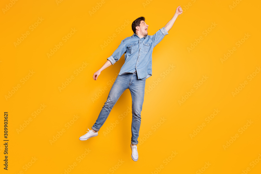 Full length body size photo of stylish trendy man being carried away with umbrella by gust of strong wind blowing isolated vivid color background Full length body size photo of stylish trendy man being carried away with umbrella by gust of strong wind blowing isolated vivid color background