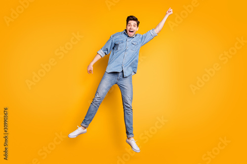 Full length body size photo of cheerful screaming positive man in white footwear flying away with umbrella by wind blowing isolated vivid color background
