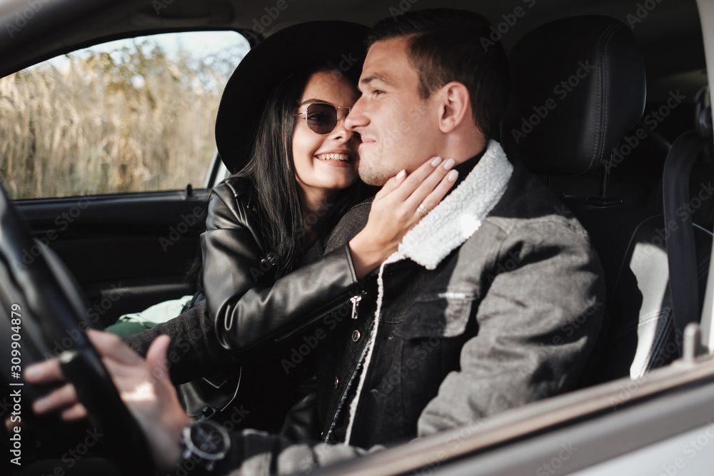 Happy Traveling Couple Dressed in Black Stylish Clothes Enjoying a Road Trip Sitting Inside the Car, Vacation Concept Happy Traveling Couple Dressed in Black Stylish Clothes Enjoying a Road Trip Sitting Inside the Car, Vacation Concept