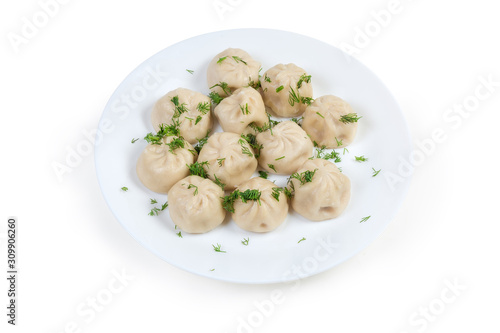 Boiled khinkali with chopped dill on dish on white background