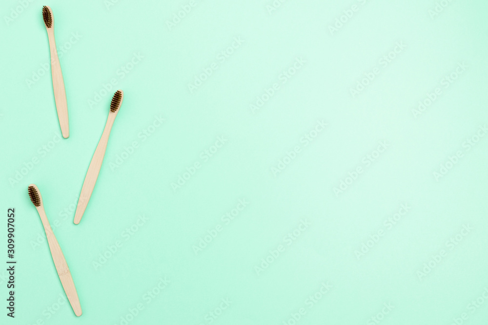 Frame made of bamboo toothbrushes on mint background Frame made of bamboo toothbrushes on mint background