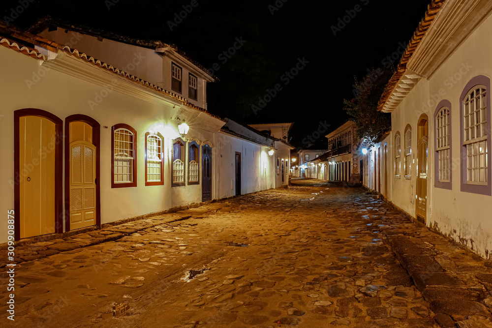 Fototapeta premium Atmospheric night view of illuminated street and buildings in historical center of Paraty, Brazil, Unesco World Heritage
