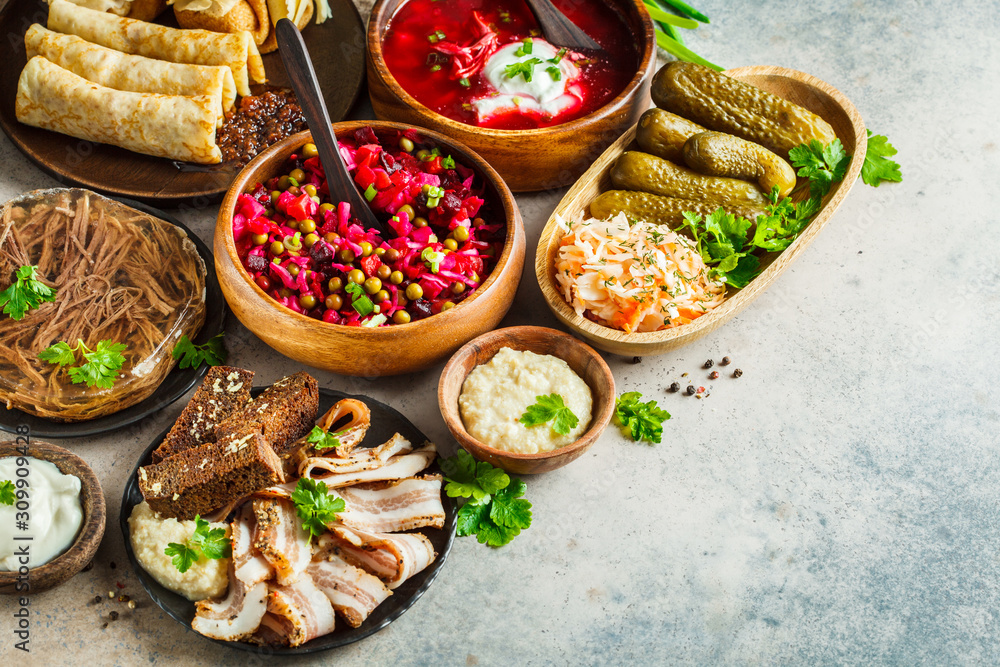Traditional Russian cuisine concept. Borsch, jellied meat, lard, crepes, salad vinaigrette and sauerkraut, gray background. Traditional Russian cuisine concept. Borsch, jellied meat, lard, crepes, salad vinaigrette and sauerkraut, gray background.