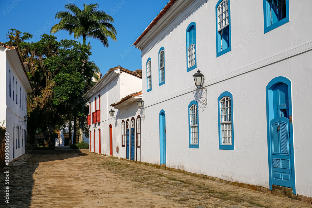 Typical cobblestone street covered with mud from high tide with colonial buildings on a sunny day in historic town Paraty, Brazil