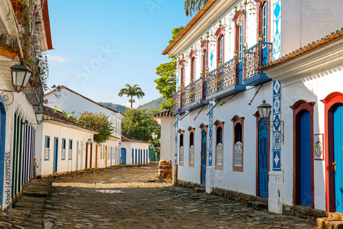 View to a cobblestone street with artful decorated house facades in historic town Paraty, Brazil photo