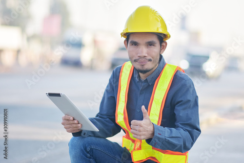 Engineering Holding tablet Highway transportation on road background,Engineer use tablet technology analysis data to planing work construction