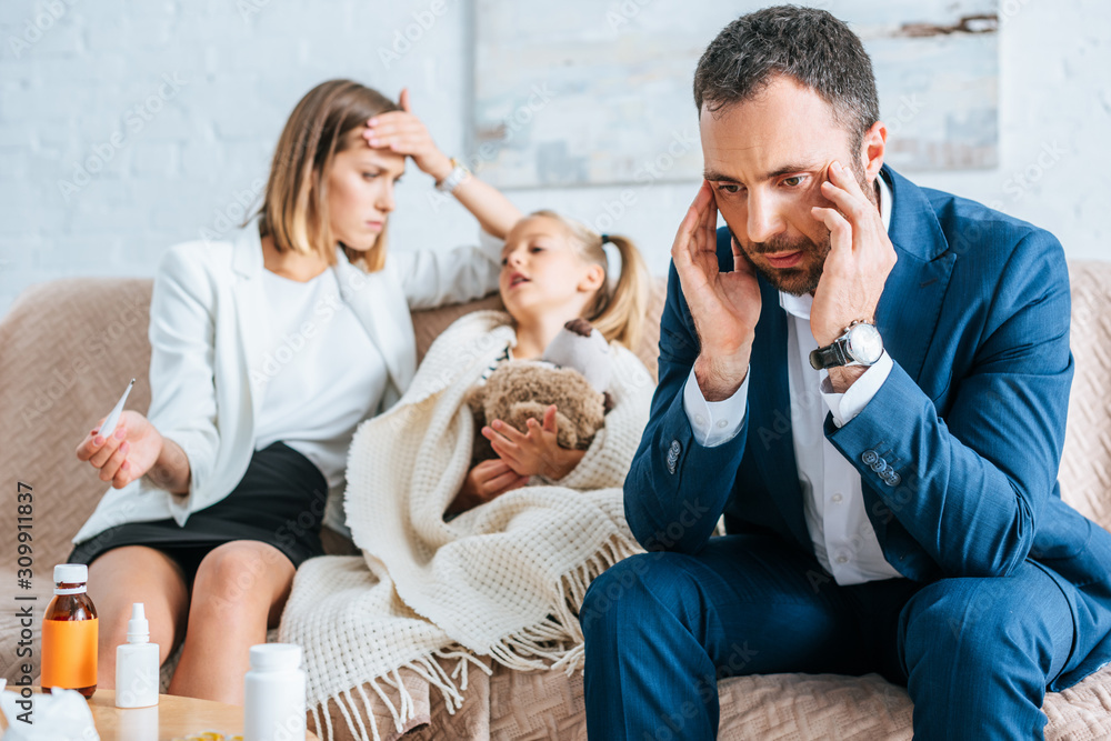 worried father touching head and mother sitting near diseased daughter worried father touching head and mother sitting near diseased daughter