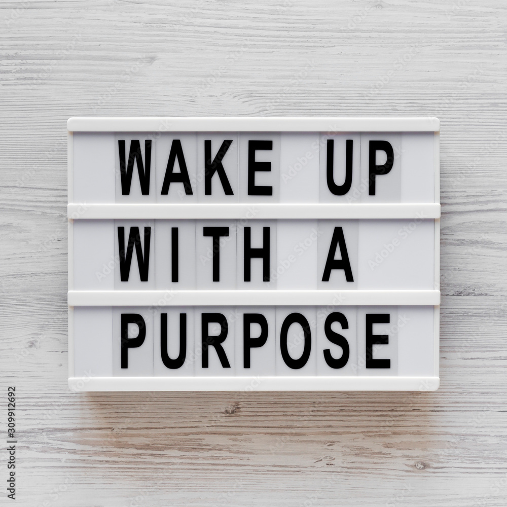 'Wake up with a purpose' words on a modern board on a white wooden background, top view. Overhead, from above, flat lay. 'Wake up with a purpose' words on a modern board on a white wooden background, top view. Overhead, from above, flat lay.