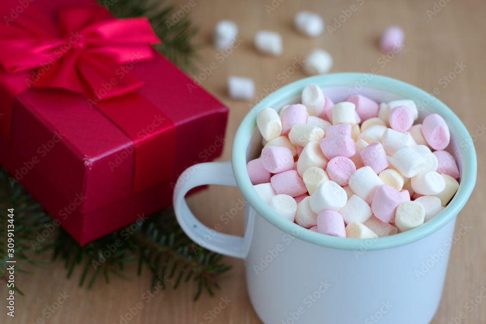 Container with marshmallows and red gift box on the wooden table - Christmas holidays Container with marshmallows and red gift box on the wooden table - Christmas holidays