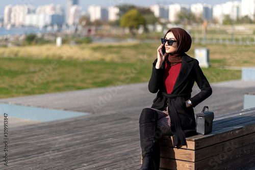 happy muslim young woman talking by phone