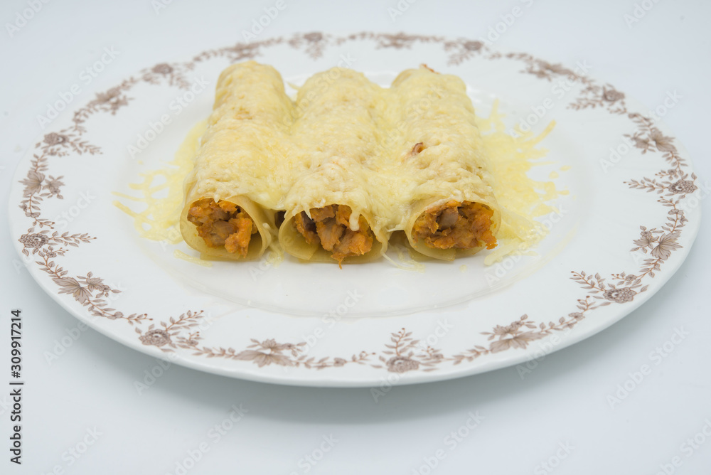 meat filled pasta on a plate. Italian cannelloni, Spanish canelones. meat filled pasta on a plate. Italian cannelloni, Spanish canelones.
