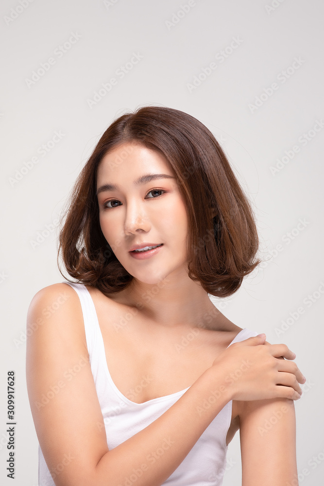 Beautiful Young Asian Woman with short hairs Touching Shoulder feeling so happy and cheerful with healthy Clean and Fresh skin,isolated on gray background,Beauty Cosmetology Concept Beautiful Young Asian Woman with short hairs Touching Shoulder feeling so happy and cheerful with healthy Clean and Fresh skin,isolated on gray background,Beauty Cosmetology Concept