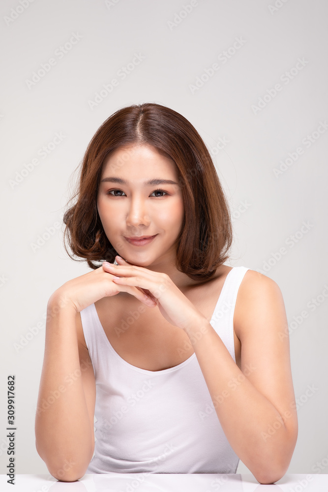 Beautiful Young Asian Woman with short hair Looking While Touching Chin feeling so happy and cheerful with healthy Clean and Fresh skin,isolated on gray background,Beauty Cosmetics Concept Beautiful Young Asian Woman with short hair Looking While Touching Chin feeling so happy and cheerful with healthy Clean and Fresh skin,isolated on gray background,Beauty Cosmetics Concept