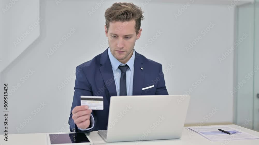 Focused Young Businessman Making Online Payment on Laptop Focused Young Businessman Making Online Payment on Laptop