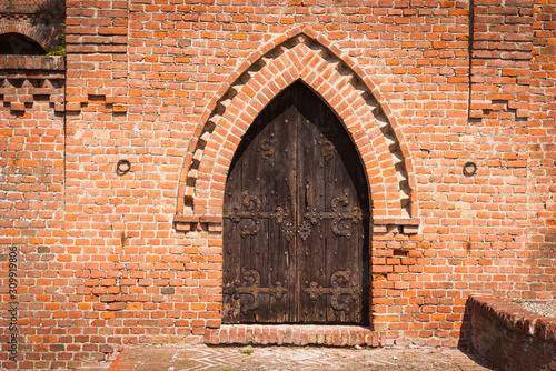 Wallpaper Mural Wooden door of an exposed brick church. Ozzano Monferrato Torontodigital.ca