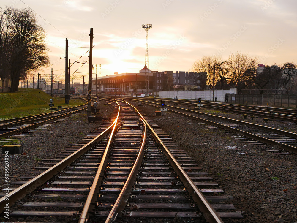Obraz premium Railway at sunset. Railway station against at sunset. Industrial landscape with a railway. Railway junction. Heavy industry. Evening on the road