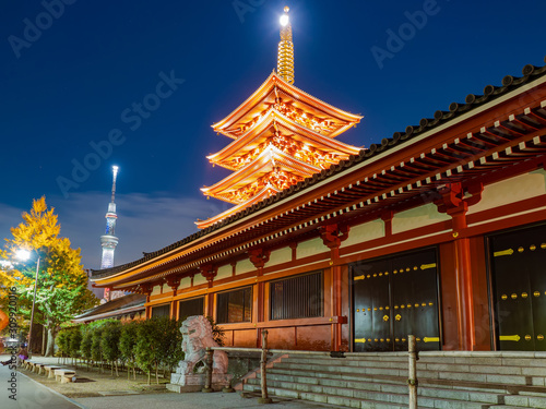 Japan. Tokyo. Asakusa Temple. Tokyo Sky Tree at night. Spire of the Asakus Pagoda glows. Highlighting a Buddhist temple at night. Sights of Tokyo. Monument to the lion at the entrance to Sensoji.