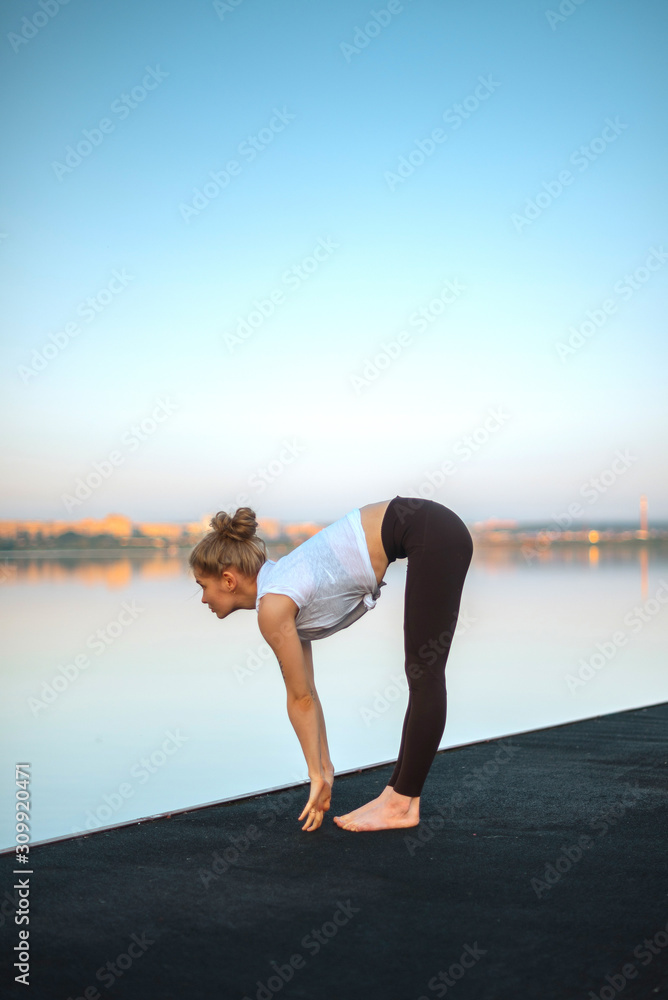 Girl practice yoga early morning on pier