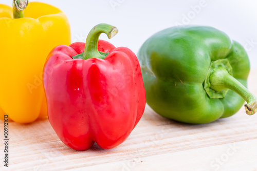Colorful peppers placed on a wooden table.