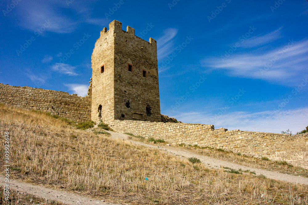 Medieval Genoese fortress on shore of Theodosius Bay in southern part of city. Close-up of fortification tower of Genoese fortress Kafa. Feodosia, Crimea, Russia, September, 2019: 