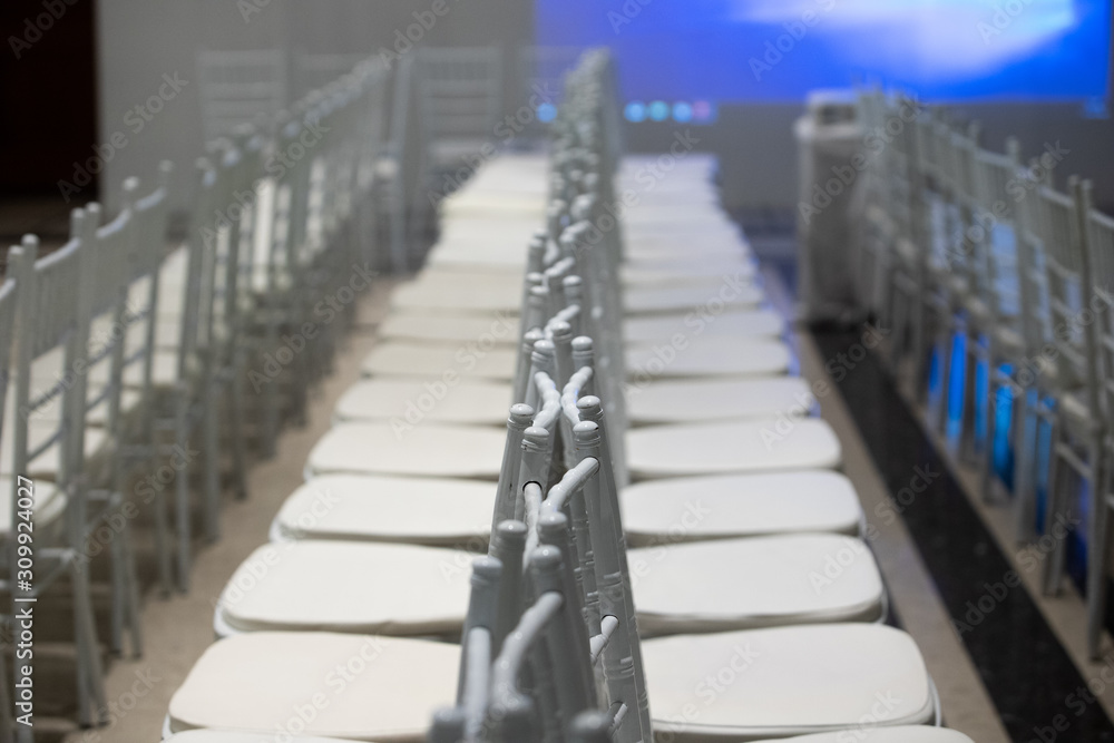 Fototapeta premium White color coatted on wooden chair Fabric Cloth Empty Many Seats Row Column in Movie Theatre Concert or Siminar Conference room
