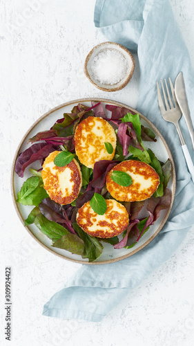 Cyprus fried halloumi with salad mix, beet tops. Lchf, pegan, fodmap, paleo, scd, keto, ketogenic diet. Balanced food, clean eating recipe. Top view, white background, vertical