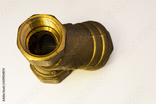 Brass coarce filter for plumbing work. Isolated, closeup. photo