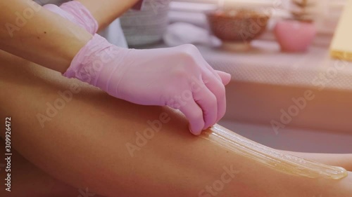 Female legs depilation by honey or sugar pasta. Sugaring hair removal. Beauty concept. Sugaring. Epilation process. Legs.  photo