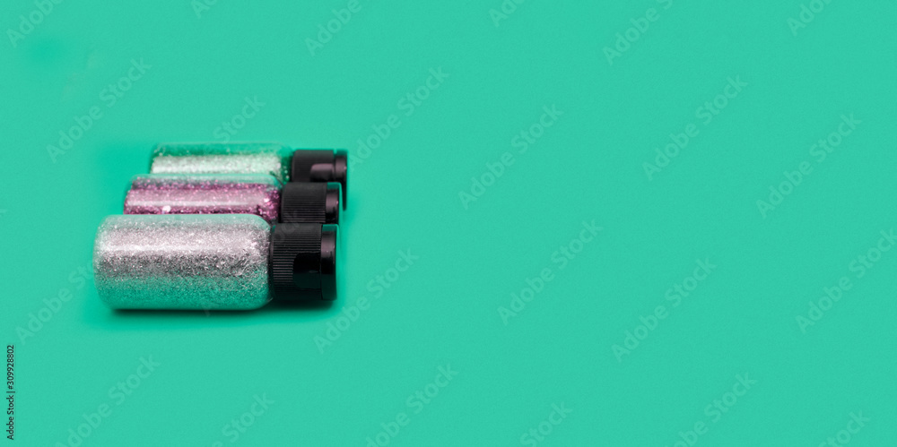 Colorful glitters on a flat lay photo, can fit for banners or craft instagram, with a green turquoise background Colorful glitters on a flat lay photo, can fit for banners or craft instagram, with a green turquoise background