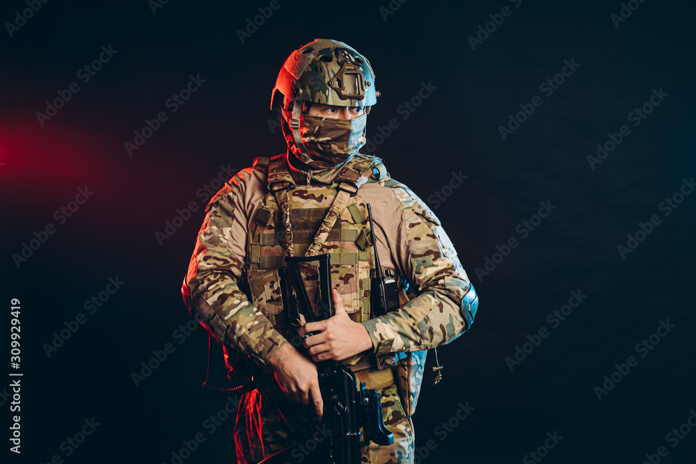 brave and strong soldier in military uniform holding rifle in hands. military service concept
