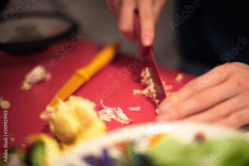 Frau schneidet Knoblauch auf einem Brett photo