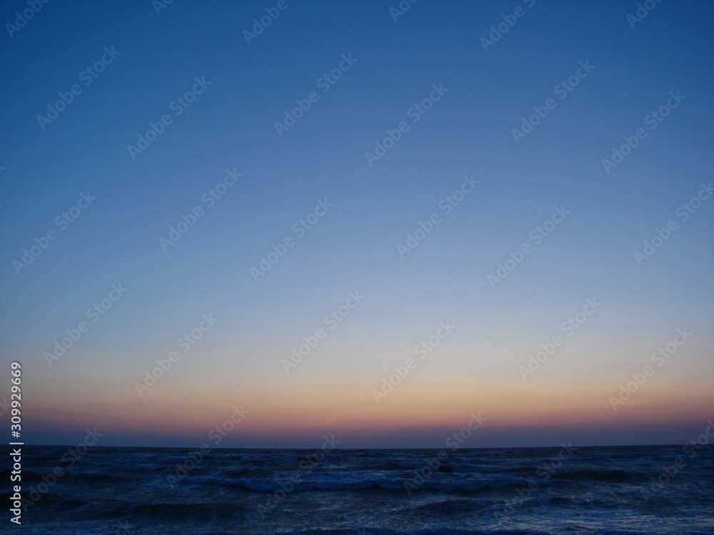 Incredible natural picture of a colorful sky over the stormy blue infinity of the Azov Sea at dawn.