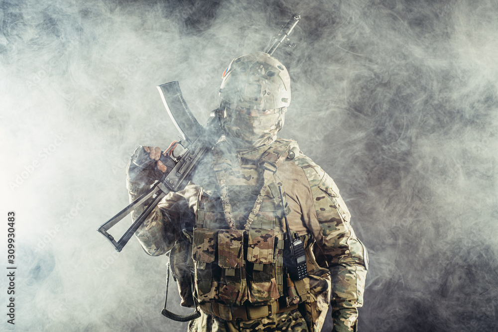 portrait of young army soldier in action with gun, dark and foggy background portrait of young army soldier in action with gun, dark and foggy background