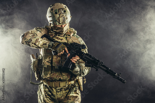 military, army, soldiers concept. brave young soldier prepare to attack holding gun in white foggy space