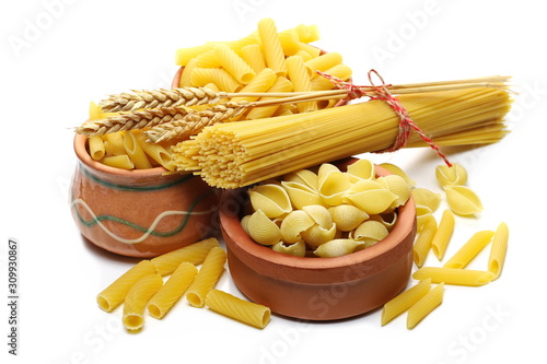 Conchiglie grandi, penne rigate and tortiglioni pasta in clay pot, bowl with spaghetti bundle isolated on white background