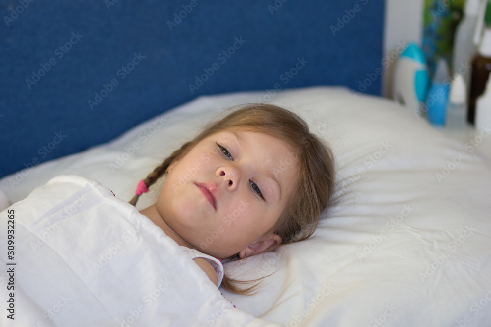Caucasian sad unhealthy child of three age lying in the bed looking aside during day Caucasian sad unhealthy child of three age lying in the bed looking aside during day